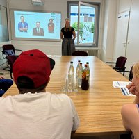 Trainerin präsentiert Auszubildenden in einem Seminarraum Tipps für Bewerbungsgespräche.